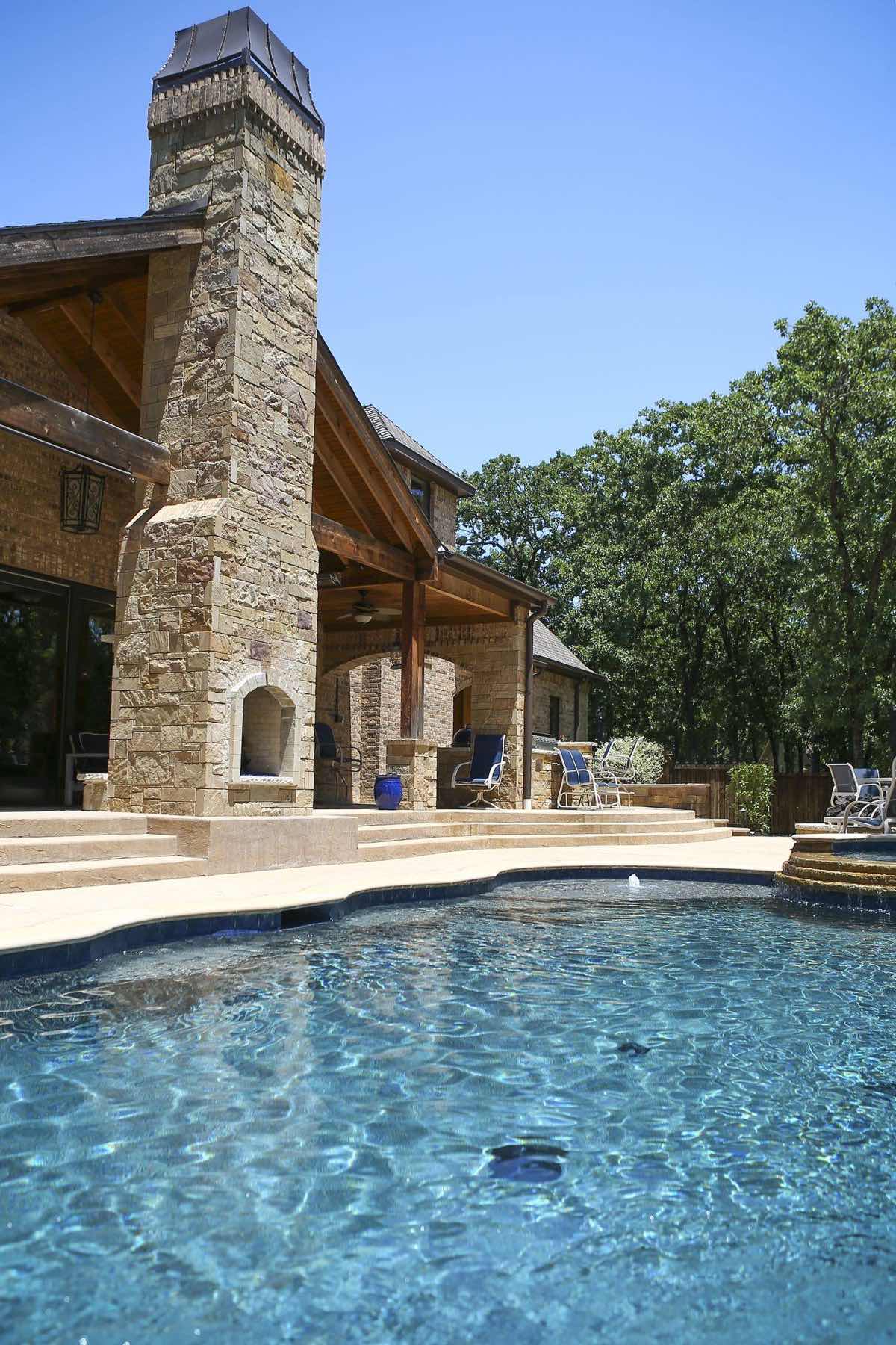 Westlake-area pool and outdoor living space with stone fireplace