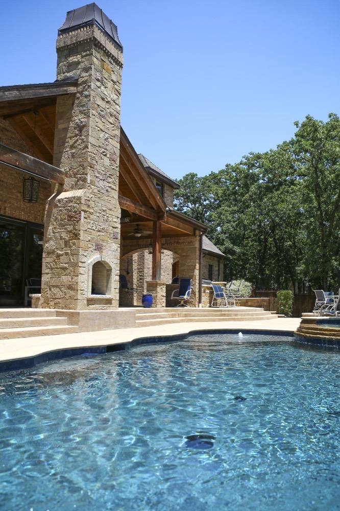 Pool and outdoor living area with stone fireplace