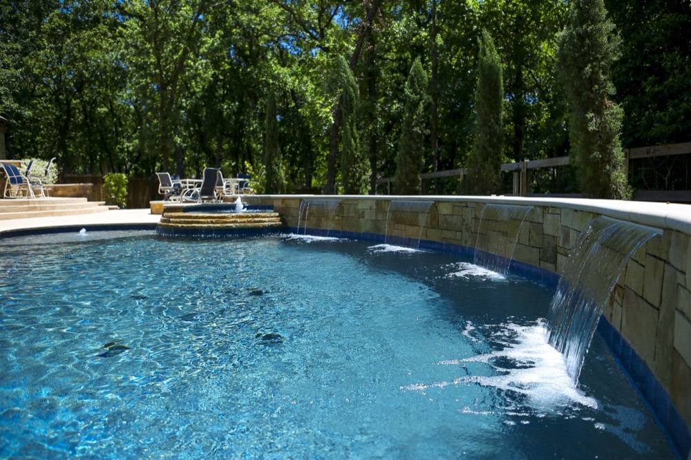 Remodeled pool with stone wall and sheer descent waterfalls
